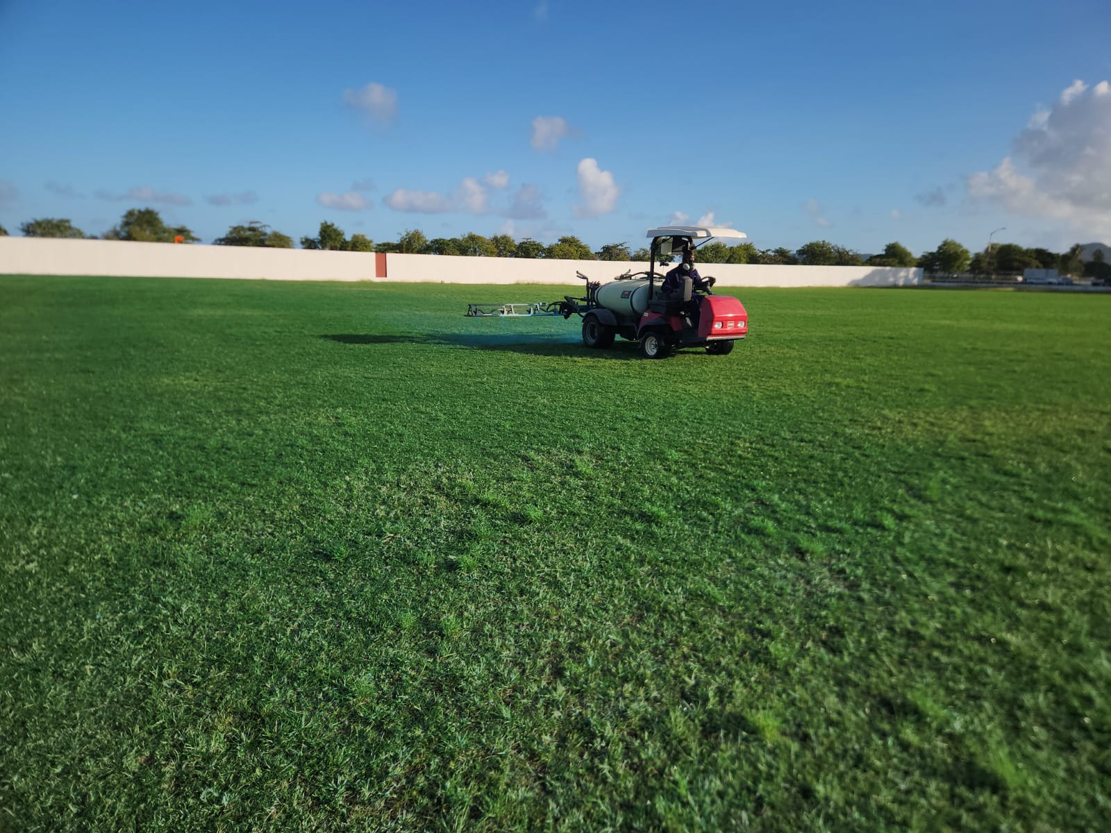 Active turf maintenance at Vigie Sports Field in Saint Lucia with Turf Pro Landscaping using specialized equipment for consistent field quality.
